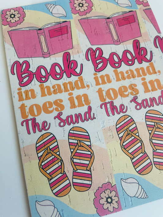 Book in hand toes in the sand
